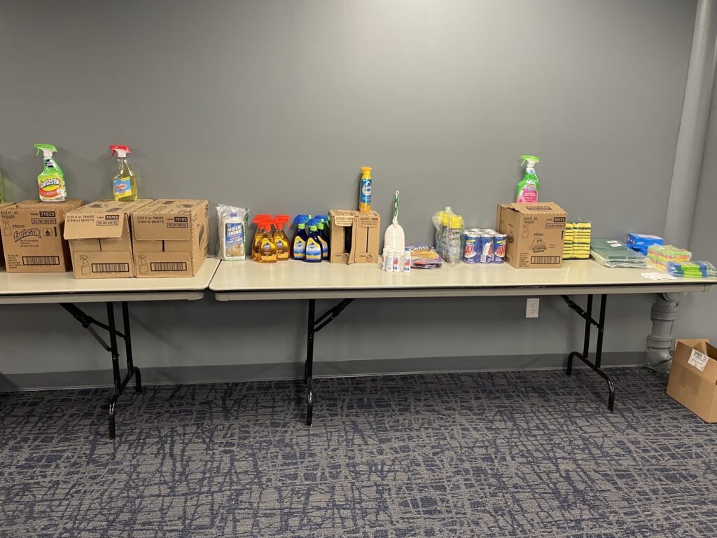 Table in a conference room with donated household items on it.